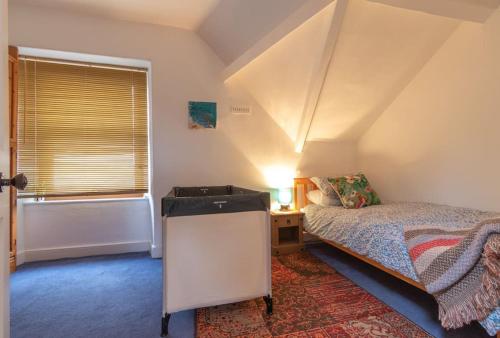 1 dormitorio con cama, ventana y bañera en Ivy Mount - Your gateway to the Yorkshire 3 Peaks, en Ingleton