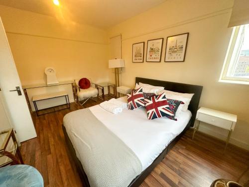 sypialnia z dużym łóżkiem z patriotycznymi poduszkami w obiekcie Eversholt flats w Londynie