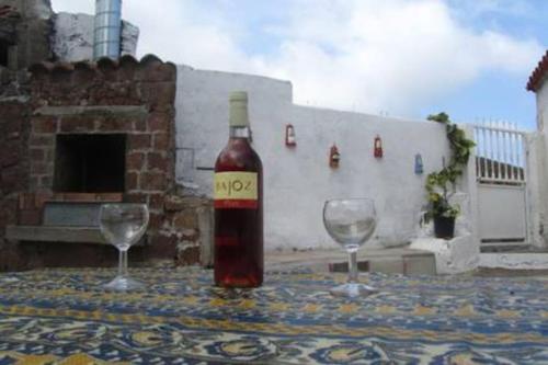 a bottle of wine sitting on a table with two glasses at House Rural,Biosphere Reserve World.Taganana.Tfe. in Santa Cruz de Tenerife