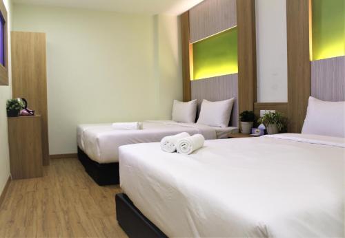 una camera d'albergo con due letti e asciugamani di Xpeed Holiday Hotel a Kuala Lumpur