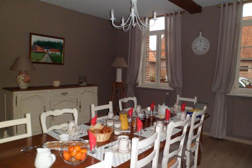 a dining room with a table and chairs at Gîte de la Noyelle à Sainghin en Mélantois in Sainghin-en-Mélantois