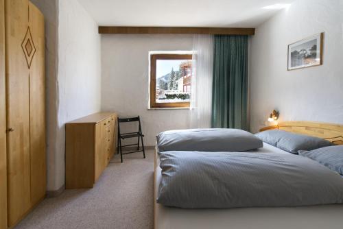 a bedroom with two beds and a desk and a window at Ostbacher Stern in Leutasch