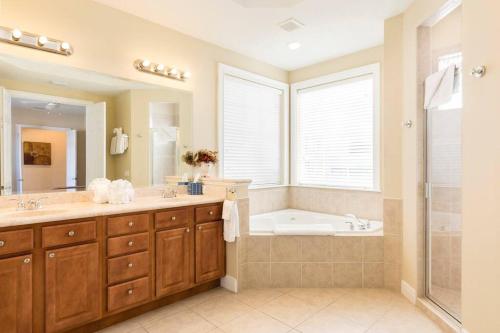 a bathroom with a tub and a sink and a shower at Reunion Resort pool home with hot tub / 4 bedrooms in Kissimmee