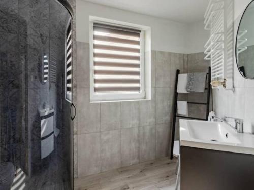 uma casa de banho com um lavatório e uma janela em Mesterki em Jastarnia