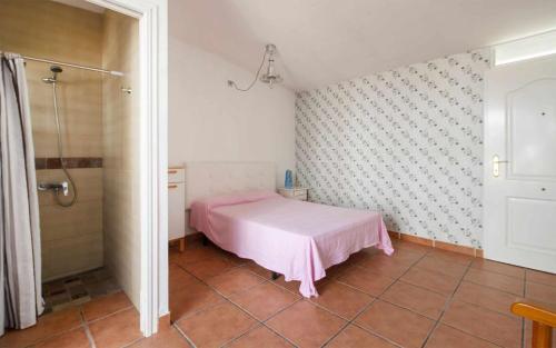 a bedroom with a pink bed and a shower at Casa Angels Tossa de Mar parking y wifi in Tossa de Mar