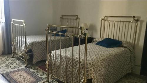 sypialnia z 2 łóżkami i niebieskimi poduszkami w obiekcie La Almedina: Palacio de Foronda w mieście Cazorla