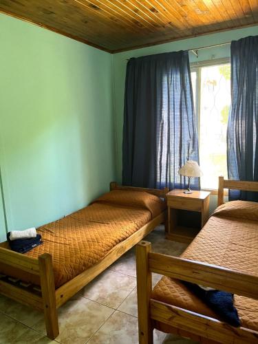 a bedroom with two beds and a window at La Diadema Casa de Montaña in Potrerillos