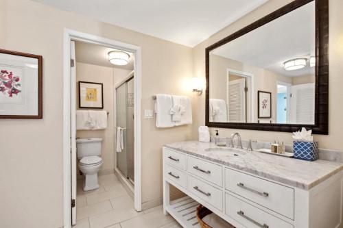 a bathroom with a sink and a toilet and a mirror at K B M Resorts Napili Villa C31 Ocean Front 2BDRM in Kapalua