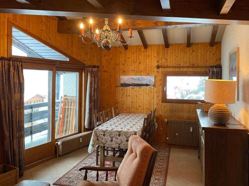 une salle à manger avec une table et un lustre dans l'établissement Appartement T3 cosy avec balcon, proche pistes de ski, parking, cheminée et WIFI - La Clusaz - FR-1-459-201, à La Clusaz