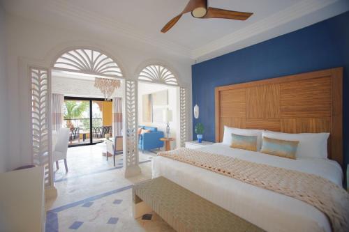 a bedroom with a large bed with a blue wall at Sanctuary Cap Cana, a Luxury Collection All-Inclusive Resort, Dominican Republic in Punta Cana