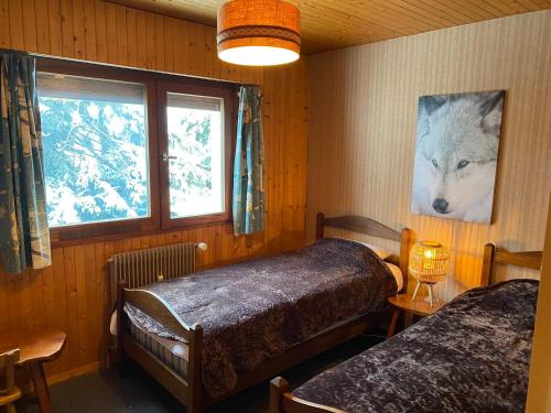 - une chambre avec 2 lits et une photo de loup dans l'établissement Appartement T3 cosy avec balcon, proche pistes de ski, parking, cheminée et WIFI - La Clusaz - FR-1-459-201, à La Clusaz