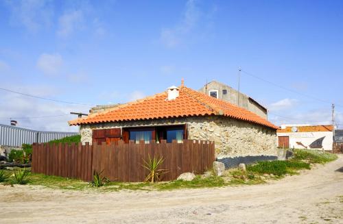 uma pequena casa com um telhado laranja numa estrada de terra em Mökki Apúlia em Apúlia