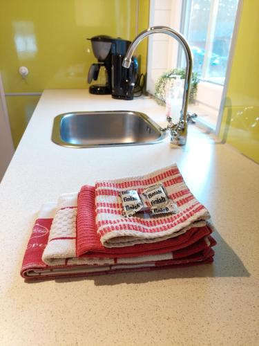 une pile de serviettes assises sur un comptoir à côté d'un lavabo dans l'établissement Sandaholm Camping, Bad och Restaurang, à Årjäng
