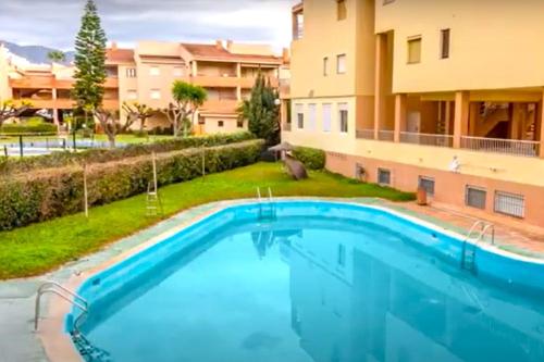 una gran piscina frente a un edificio en Apartamento con la playa a 200 metros, en Granada