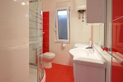 ein Badezimmer mit einem weißen Waschbecken und einem WC in der Unterkunft Apartman Slavko in Seget Vranjica