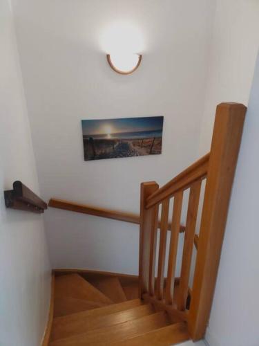 un escalier en bois avec une photo sur le mur dans l'établissement Maison au coeur de Saint-Gilles L'Inattendue, à Saint-Gilles-Croix-de-Vie