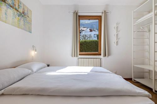 um quarto branco com uma cama e uma janela em Casa Milani Malcesine apt 4 em Malcesine