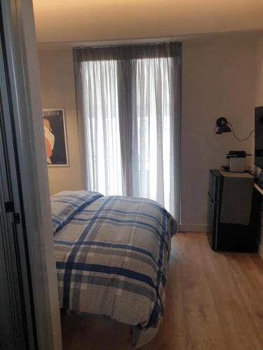 1 dormitorio con 1 cama frente a una ventana en Tiny studio 2 min walking distance from the port, en Volos