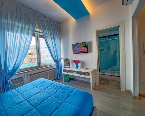 een slaapkamer met een blauw bed en een raam bij Giulia BB Sorrento in Sorrento