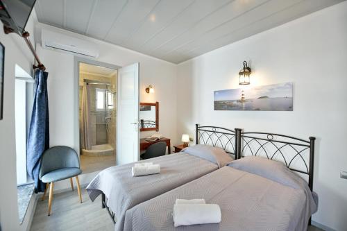 a bedroom with two beds with towels on them at Delfini Hotel in Hydra