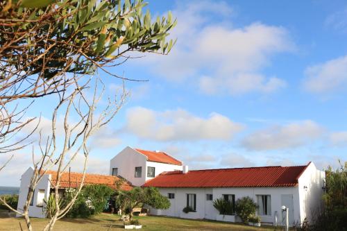 a white house with a red roof at Guesthouse Entre Campo y Mar in La Coronilla
