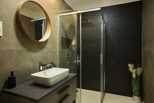 a bathroom with a sink and a shower with a mirror at Sunlight Green - Szeged in Szeged
