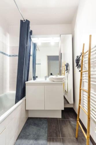 une salle de bain avec un lavabo blanc et un miroir dans l'établissement Appartement confortable proche Disneyland Paris, à Bussy-Saint-Georges