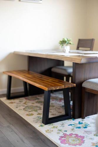 a wooden table with a bench on top of a rug at King & Queen Memory Foam Beds 2-2b Georgetown Villas in Fairview Park
