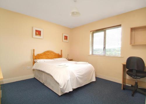 a bedroom with a bed and a desk and a window at Ballyraine Self Catering in Letterkenny