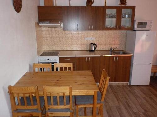 a kitchen with a wooden table with chairs and a refrigerator at U Zámku in Stráž nad Nežárkou