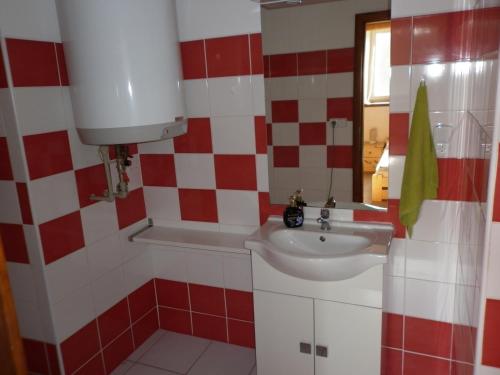 baño rojo y blanco con lavabo y bañera en U Zámku, en Stráž nad Nežárkou