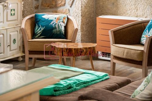 a living room with two chairs and a table at Casa da Pausa by TonsdeVerde in Vila Verde