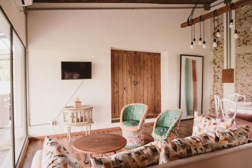 a living room with a couch and a table and chairs at El Rincón. Farm and Lodge in Carmelo