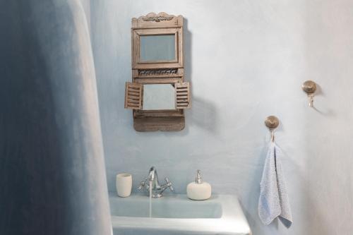 a bathroom with a sink and a mirror on the wall at Villa Fani Kythnos in Kithnos