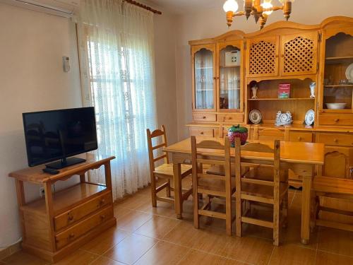 a kitchen and dining room with a table and a television at CASA BRIGIDA in Jerte