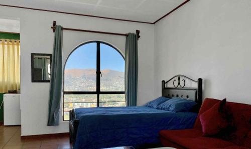 a bedroom with a bed and a large window at Casa Santiago in Oaxaca City