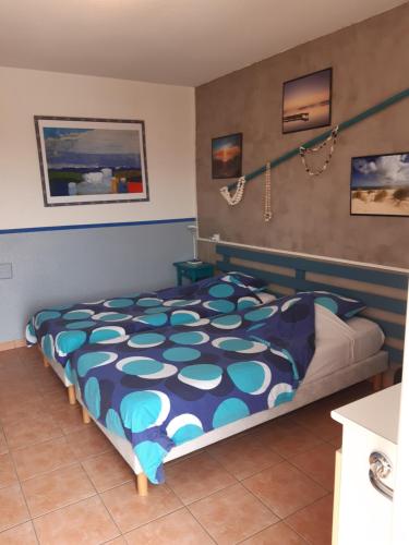 une chambre avec un lit avec une couette bleue et blanche dans l'établissement LE RELAIS BLEU, à Capestang