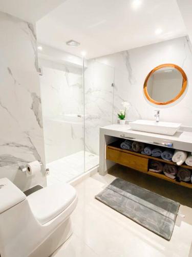 a bathroom with a toilet and a sink and a mirror at Large Beach Front 2bed/2bath Condo: Save $50+/nt! in Puerto Vallarta
