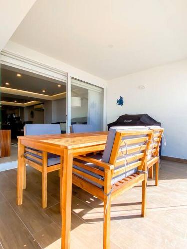 a wooden table with four chairs around it at Large Beach Front 2bed/2bath Condo: Save $50+/nt! in Puerto Vallarta