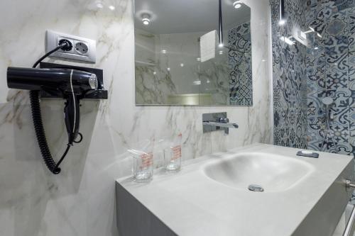a bathroom with a sink and a phone on the wall at Ferhadija 31 Old town Sarajevo in Sarajevo