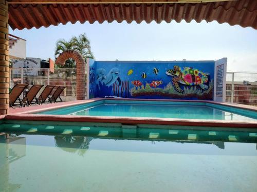 a swimming pool with a mural on the wall at Hotel Valeria in Tecolutla