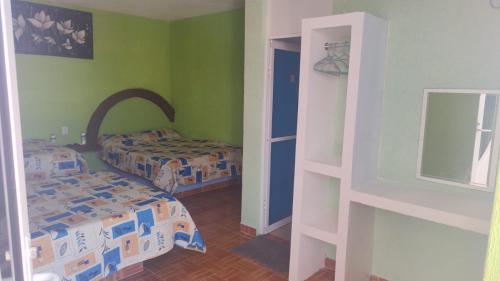 a bedroom with two beds and a door to another room at Hotel Valeria in Tecolutla