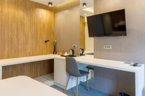 a hotel room with a desk with a television on the wall at Ferhadija 31 Old town Sarajevo in Sarajevo