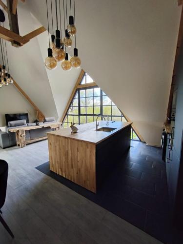 a kitchen with a large island in a loft at Les Délices de la Vie in Le Mesnil-Germain