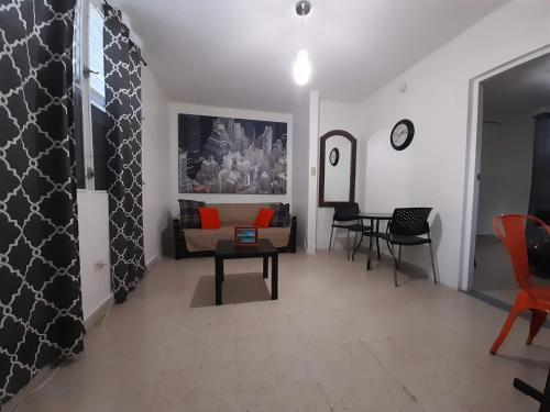 un soggiorno con un divano e un tavolo di Cozy Apartment across the San Juan Airport a San Juan