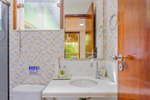 La salle de bains est pourvue d'un lavabo, de toilettes et d'un miroir. dans l'établissement IT12 Lindo Bangalô Duplex 2 Suítes Pé na Areia, Itacimirim, à Itacimirim