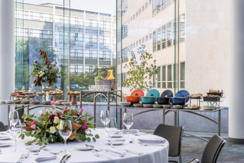 a dining room with tables and chairs and a large window at Andaz Condesa Mexico City, By Hyatt in Mexico City