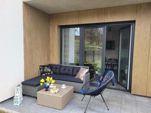 a patio with a couch and a table and a chair at Apartament Nina in Jelenia Góra