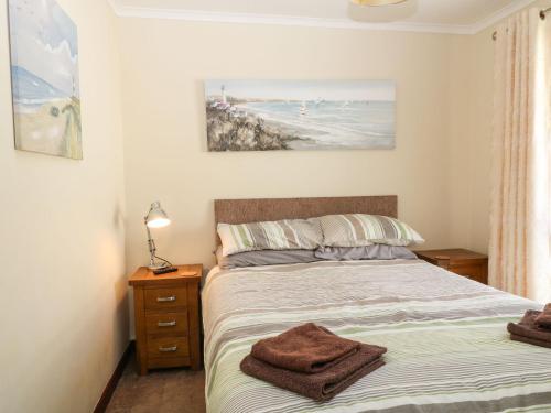 a bedroom with a bed and a view of the beach at Willow Lodge in Liskeard