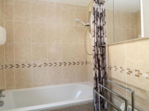 a bathroom with a white tub and a shower at Willow Lodge in Liskeard